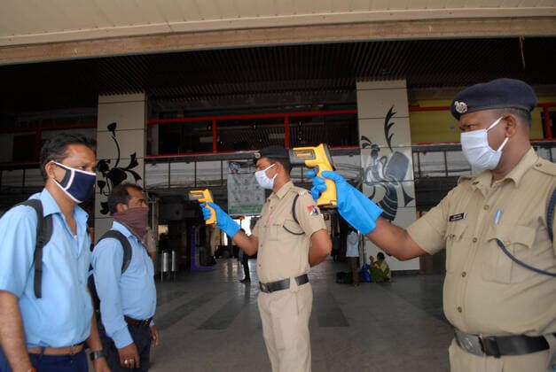 India: Civil curfew against COVID-19 Security person checks temperature of Passengers during a one-day Janata (civil) curfew imposed as a preventive measure against the COVID-19 coronavirus, in Kolkata on March 22, 2020. Nearly one billion people around the world were confined to their homes, as the coronavirus death toll crossed 13,000 and factories were shut in worst-hit Italy after another single-day fatalities record. West Bengal India Copyright: DipaxChakraborty