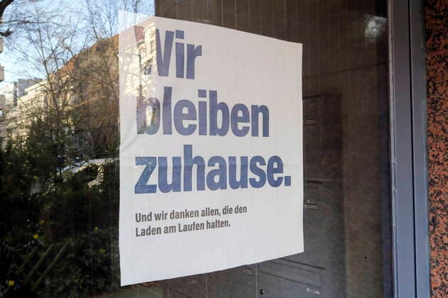 22.03.2020, Berlin, Deutschland - Corona-Krise. Foto: Zettel an der Haustuer eines Wohnhauses in Berlin mit der Aufschrift - Wir bleiben zuhause. Und wir danken allen, die den Laden am Laufen halten.