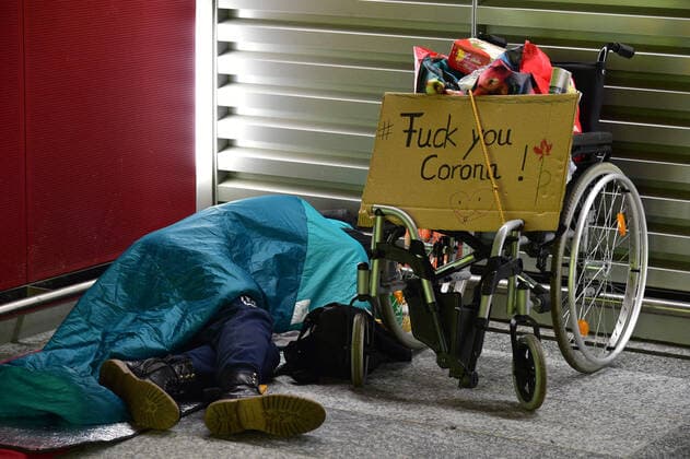 Der Flughafen Frankfurt ist am Sonntag (22.3.2020) während der Ausgangsbeschränkungen in der Corona-Krise nahezu verwaist. Im Abflugbereich ist wenig los, viele Flüge fallen aus. Dieser Obdachlose zeigt Protest.
