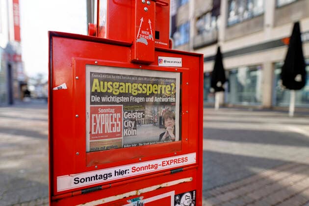Die menschenleere Schildergasse mit Schlagzeile der Kölner Boulevardzeitung Kölner Express zu einer möglichen Ausgangssperre während der Corona-Krise. Köln, 22.03.2020