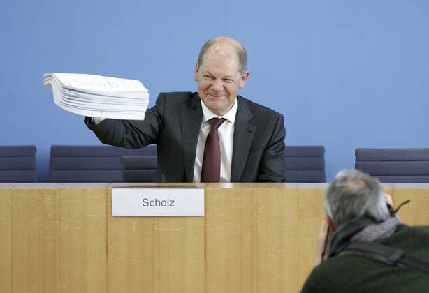 Bundesfinanzminister Olaf Scholz, SPD, spricht in der Bundespressekonferenz zum Nachtragshaushalt 2020 und die Reaktion auf die Corona-Krise. Hier haelt er einen Aktenstapel mit den neunen Gesetzen in die Kamera. Berlin, 23.03.2020 Berlin Deutschland