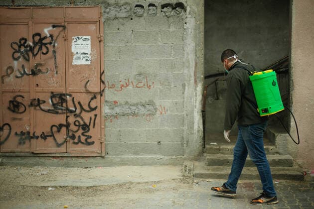 Coronavirus precautions in Gaza A member of a volunteer group carries out disinfection works as a precaution against the coronavirus (COVID-19) pandemic at a shopping area in Beit Lahia, north of Gaza, Gaza. Gaza Palestine Copyright: RamezxHabboub