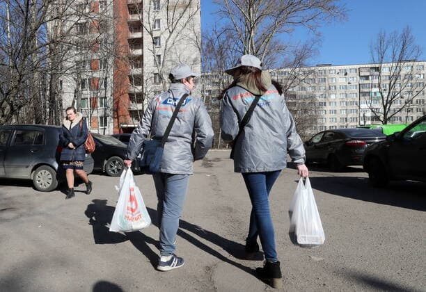 ST PETERSBURG, RUSSIA - MARCH 23, 2020: Medical volunteers delivering groceries to elderly people in quarantine amid the COVID-19 coronavirus pandemic. Medical volunteers and the Russian Popular Front are opening volunteer centers to help the elderly who are at higher risk of COVID-19 and are staying at home to avoid the coronavirus infection. Alexander Demianchuk TASS  TS0D3248
