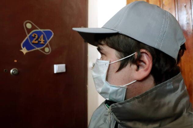 ST PETERSBURG, RUSSIA - MARCH 23, 2020: A medical volunteer delivering groceries to elderly people in quarantine amid the COVID-19 coronavirus pandemic. Medical volunteers and the Russian Popular Front are opening volunteer centers to help the elderly who are at higher risk of COVID-19 and are staying at home to avoid the coronavirus infection. Alexander Demianchuk TASS  TS0D3249