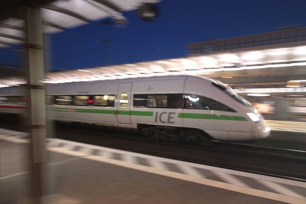 ICE 3 der DB Deutsche n Bahn mit grün em Band bei der Abfahrt vom Hauptbahnhof Frankfurt in der Abenddämmerung, Hessen, Deutschland