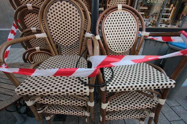 Mit Absperrband festgebundene Stühle eines geschlossenen Café s in der Innenstadt Mannheim, Baden Württemberg, Deutschland