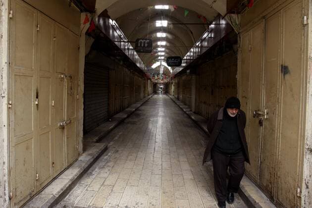 (200323) -- NABLUS, March 23, 2020 -- A Palestinian man walks past closed shops on an empty street in the West Bank City of Nablus, March 23, 2020. Palestinian authorities on Sunday declared a 14-day lockdown on the West Bank as part of measures to combat the spread of coronavirus pandemic. Prime Minister Mohammed Ishtaye announced a ban on transportation and movement between the West Bank districts, urging citizens to stay at home. (Photo by Nidal Eshtayeh Xinhua) MIDEAST-NABLUS-COVID-19-MEASURES XiongxSihao 