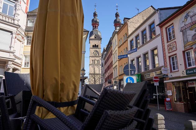 Coronavirus - Koblenz 23.03.2020, Rheinland-Pfalz, Koblenz: Stühle stehen bei Sonnenschein an einem Montag gestapelt in der Altstatt, das Geschäft muss wegen des Coronavirus ruhen. Die Stadt Koblenz ist weitgehend Menschen- und Fahrzeugleer, die die neuen Regeln greifen seit Montag und dienen der Eindämmung der Corona-Pandemie.