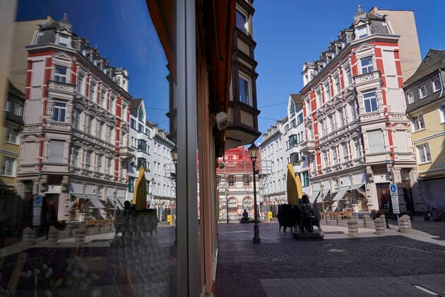 Coronavirus - Koblenz 23.03.2020, Rheinland-Pfalz, Koblenz: Die Aussenfassade einer Häuserfront Spiegelt sich in einem Schaufester. Die Stadt Koblenz ist weitgehend Menschen- und Fahrzeugleer, die die neuen Regeln greifen seit Montag und dienen der Eindämmung der Corona-Pandemie.
