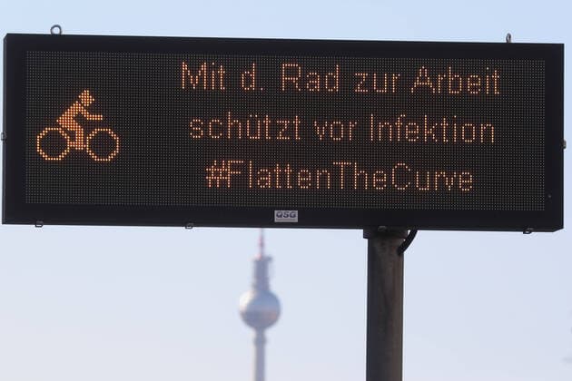 23.03.2020, Berlin, GER - Hinweis: Mit dem Rad zur Arbeit schuetzt vor Infektion. Im Hintergrund der Berliner Fernsehturm. (Alltag, Anzeige, Ausgangsbeschraenkung, Ausgangssperre, aussen, Aussenaufnahme, Berlin, Coronaepidemie, Coronainfektion, Coronapandemie, Coronavirus, Coronavirus SARS-CoV-2, Covid 19, Covid-19, deutsch, Deutschland, Europa, europaeisch, Fernsehturm, FlattentheCurve, Fruehjahr, Fruehling, Gesellschaft, Hinweis, Hinweisschild, Jahreszeit, Kontakt vermeiden, Kontaktverbot, mit dem Rad zur Arbeit, QF, Querformat, Radfahren, Shutdown, Stadt, Stadtansicht, Stadtbild, Stadtleben, Westeuropa) 200323D026BERLIN.JPG