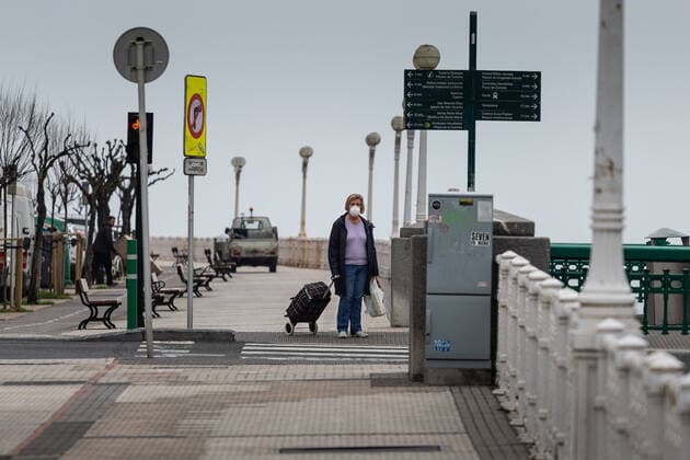 March 23, 2020, San Sebastian, Spain: A woman wearing a face mask as a precaution against the spread of Coronavirus walks with her dog on an empty street..Spain registers more than 33,000 cases of coronavirus which means an increase of around 16% of people infected by Covid 19. In addition, the number of people who died from the coronavirus is 2,182 that is 462 more than the day before, which makes Monday 23rd the worst day of the crisis in terms of deaths. San Sebastian Spain - ZUMAs197 20200323_zaa_s197_040 Copyright: xJavixJuliox