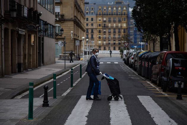 March 23, 2020, San Sebastian, Spain: A woman wearing a face mask as a precaution against the spread of Coronavirus crosses an empty street with her shopping trolley..Spain registers more than 33,000 cases of coronavirus which means an increase of around 16% of people infected by Covid 19. In addition, the number of people who died from the coronavirus is 2,182 that is 462 more than the day before, which makes Monday 23rd the worst day of the crisis in terms of deaths. San Sebastian Spain - ZUMAs197 20200323_zaa_s197_048 Copyright: xJavixJuliox