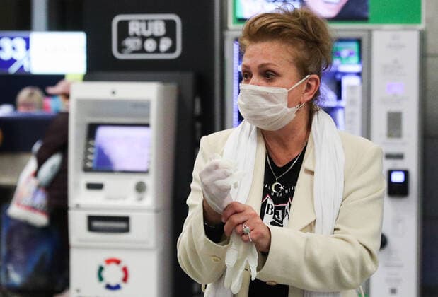 MOSCOW, RUSSIA - MARCH 23, 2020: A woman wears a face mask and gloves at Vnukovo International Airport, amid the ongoing COVID-19 pandemic. Mikhail Tereshchenko TASS  TS0D3291