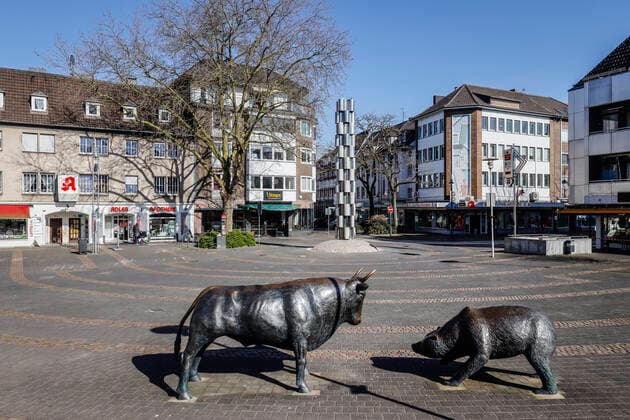 23.03.2020, Viersen, Niederrhein, Nordrhein-Westfalen, Deutschland - Kontaktsperre wegen Corona Pandemie, am Montag menschenleere Einkaufsstrasse mit geschlossenen Geschaeften in der Viersener Altstadt, hier Bulle und Baer auf dem Platz vor der Sparkasse an der Hauptstrasse. Viersen Nordrhein-Westfalen Deutschland