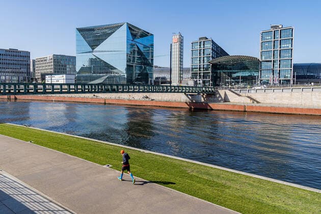 23.03.2020, Berlin, Deutschland, GER - Impressionen aus Berlin während der Ausgangsbeschränkung: Jogger läuft an der sonst menschenleeren Uferpromenade der Spree entlang.