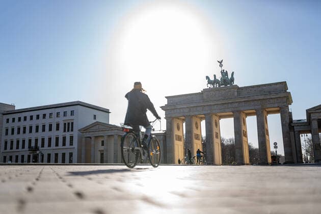 23.03.2020, Berlin, Deutschland, GER - Impressionen aus Berlin während der Ausgangsbeschränkung: Fahrradfahrerin fährt auf dem leeren Pariser Platz.