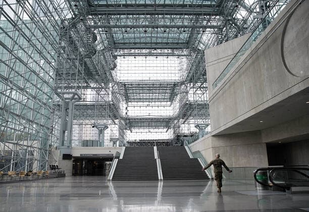A National Guard man in uniform walks through an empty Jacob Javits Convention Center before Gov. Andrew Cuomo speaks with the National Guard on site in New York City on Monday, March 23, 2020. The Javits Center is setting up to be turned into field hospitals to test and possibly treat cases of COVID-19 infections. New York state now accounts for about 1 percent of the coronavirus-related deaths in the world and New York City has more than 12,300 of those cases.  NYP20200323105 JOHNxANGELILLO