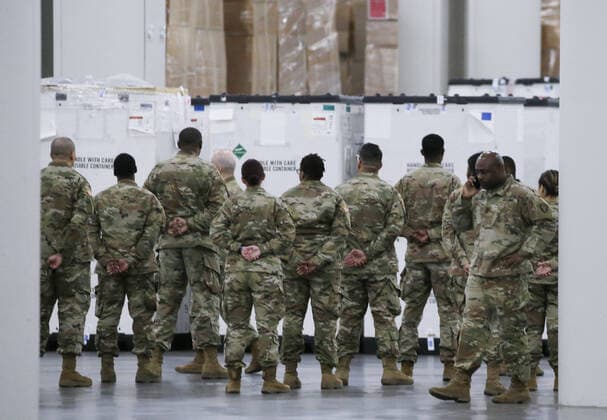 Members of the National Guard stand with boxes of medical supplies at the Jacob Javits Convention Center before Gov. Andrew Cuomo speaks with the National Guard on site in New York City on Monday, March 23, 2020. The Javits Center is setting up to be turned into field hospitals to test and possibly treat cases of COVID-19 infections. New York state now accounts for about 1 percent of the coronavirus-related deaths in the world and New York City has more than 12,300 of those cases.  NYP20200323121 JOHNxANGELILLO