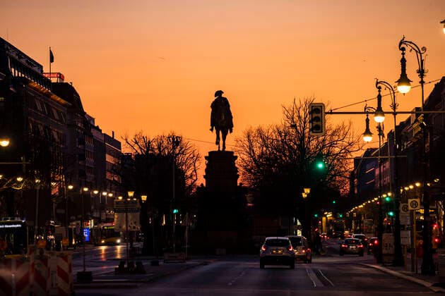 Leeres Unter den Linden mit Blick auf der Quadriga und Brandenburger Tor waehrend der Sonnenuntergang in Berlin am 23. Maerz 2020. Um die Verbreitung des Coronavirus (COVID-19) zu verlangsamen beschlossen Bund und Laender weitere Restriktionen. Nachdem Museen, Theatern, Sportveranstaltungen usw verboten wurden sind ab heute Versammlungen mit mehr als zwei Personen in der Oeffentlichkeit grundsaetzlich verboten. Restaurants koennen zum Beispiel nur nich Abholung anbieten. In den Strassen sind ganz wenige Menschen auf den Weg. Oeffentliches Leber weiter in Berlin wegen Coronavirus eingeschraenkt