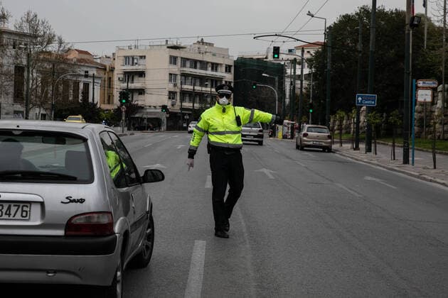 (200323) -- ATHENS, March 23, 2020 -- A policeman stops a car to check documents in Athens, Greece, on March 23, 2020. City streets across Greece were deserted as the government launched on Monday a 14-day nationwide lockdown in an effort to contain the further spread of the COVID-19. Greece has registered so far 17 deaths linked to COVID-19, up from 15 reported a day earlier and 71 new confirmed cases, bringing the total to 695. (Photo by Xinhua) GREECE- ATHENS-COVID19-LOCKDOWN LEFTERISxPARTSALIS 