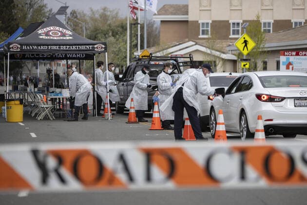 Hayward emergency-medical technicians check members of the public for symptoms and high temperature at a Coronavirus drive up triage station in Hayward, California on Monday, March 23, 2020. If the individual has symptoms, they are directed to be tested for CIVID-19 at a separate testing tent.  SFP2020032329 PETERxDASILVA
