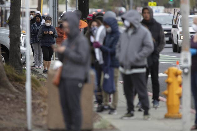 Members of the public practice social distancing while waiting in line to be checked by Hayward emergency-medical technician for symptoms and high temperature at a triage station for Coronavirus in Hayward, California on Monday, March 23, 2020. If the individual has symptoms, they are directed to be tested for CIVID-19 at a separate testing tent.  SFP2020032338 PETERxDASILVA
