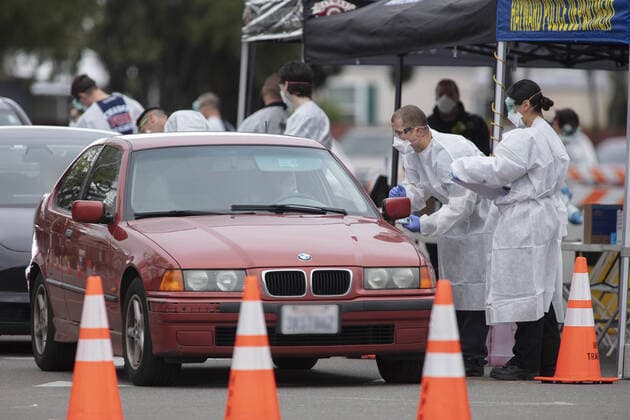 Hayward emergency-medical technicians check members of the public for symptoms and high temperature at a Coronavirus drive up triage station in Hayward, California on Monday, March 23, 2020. If the individual has symptoms, they are directed to be tested for CIVID-19 at a separate testing tent.  SFP2020032309 PETERxDASILVA