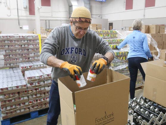 Volunteers pack food supplies for shut-in seniors at St. Louis Area Foodbank in Bridgeton, Missouri on Monday, March 23, 2020. The Foodbank is now supplying two months of seniors boxes in a single delivery so that seniors risk of social exposure is reduced due to Coronavirus concerns.  SLP2020032313 BILLxGREENBLATT