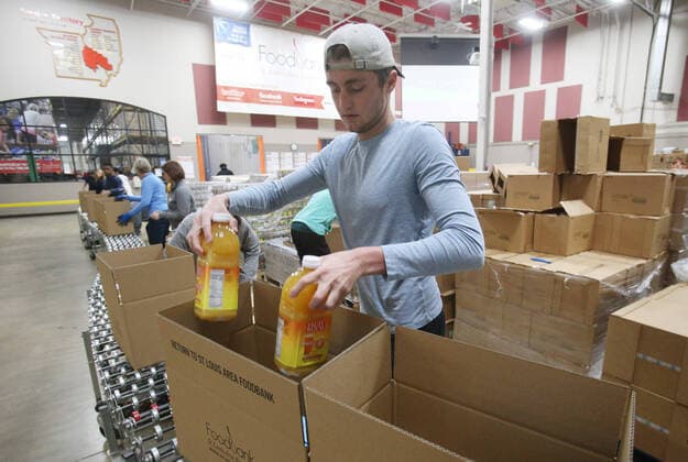 Volunteers pack food supplies for shut-in seniors at St. Louis Area Foodbank in Bridgeton, Missouri on Monday, March 23, 2020. The Foodbank is now supplying two months of seniors boxes in a single delivery so that seniors risk of social exposure is reduced due to Coronavirus concerns.  SLP2020032314 BILLxGREENBLATT