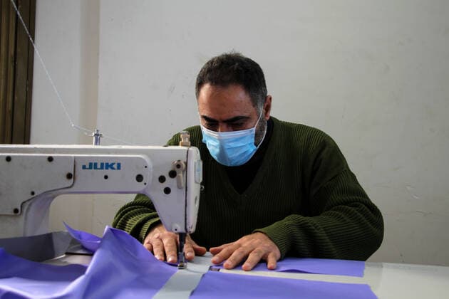 (200323) -- BEIT LAHIA, March 23, 2020 (Xinhua) -- A Palestinian worker makes a protective suit at a factory in the northern Gaza Strip town of Beit Lahia, on March 22, 2020. A Gaza factory, which is located in the coastal enclave town of Beit Lahia, has succeeded in producing protective suits following China s standards. (Photo by Rizek Abdeljawad Xinhua) TO GO WITH Feature: Gaza factory follows China s standards to produce protective suits amid COVID-19 MIDEAST-GAZA-BEIT LAHIA-COVID-19-PROTECTIVE SUITS-PRODUCTION 
