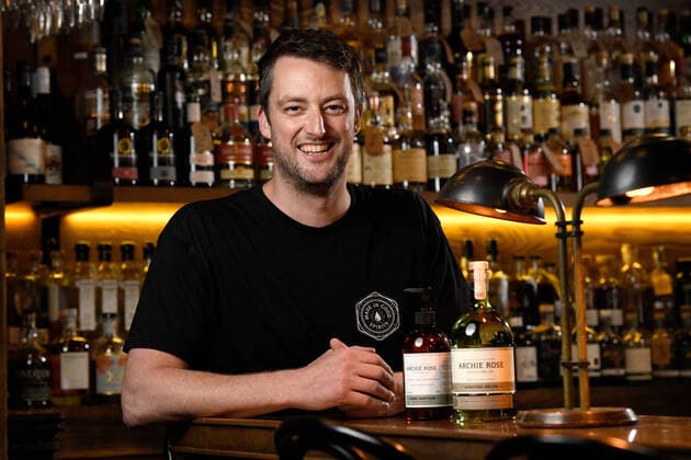 ARCHIE ROSE GIN HAND SANITISER, Archie Rose Distilling Group Bar Manager Lewis Jaffrey poses with a bottle of their Gin infused hand sanitiser and signature gin, in Sydney, Tuesday, March 24, 2020. Using leftover botanicals from their gin, the idea to produce the hand sanitiser came from trying to keep their bar staff employed during the COVID-19 shut down of license venues. The hand sanitiser has so far sold out online, but will be sold to the general public and wholesalers. ( NO ARCHIVING, EDITORIAL USE ONLY, NO USE IN BOOKS WITHOUT CONSENT SYDNEY NSW AUSTRALIA  Copyright: xBIANCAxDExMARCHIx 20200324001459061819
