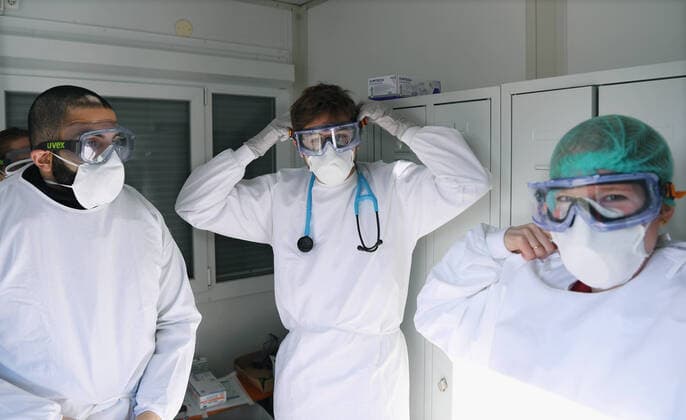 Tuebingen 24.03.2020 Corona: Container Ambulanz Tuebingen, Covid 19 Versorgung auf dem Tuebinger Festplatz. Dr. Julia Martin (re) und Medizinstudenten beim Anlegen der Schutzkleidung fuer die ambulanten Versorgung von Patienten.