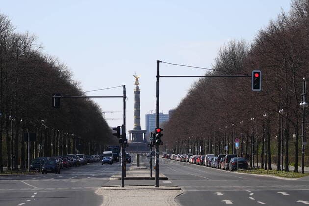 Siegessaeule mit leeren Strasse des 17. Juni in Berlin am 24. Maerz 2020. Um die Verbreitung des Coronavirus (COVID-19) zu verlangsamen beschlossen Bund und Laender weitere Restriktionen. Nachdem Museen, Theatern, Sportveranstaltungen usw verboten wurden sind ab gestern Versammlungen mit mehr als zwei Personen in der Oeffentlichkeit grundsaetzlich verboten. Restaurants koennen zum Beispiel nur nich Abholung anbieten. Die Menschen scheinen diese Massnahmen zu folgen, da die Stadt menschenleer ist. Oeffentliches Leber weiter in Berlin wegen Coronavirus eingeschraenkt