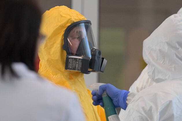 MOSCOW, RUSSIA - MARCH 24, 2020: Russia s President Vladimir Putin in a yellow protective suit sprayed with disinfectant on his visit to the Novomoskovsky multipurpose medical center for patients suspected of the COVID-19 coronavirus infection. Alexei Druzhinin Russian Presidential Press and Information Office TASS  TS0D336C