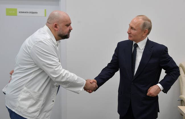 MOSCOW, RUSSIA - MARCH 24, 2020: Russia s President Vladimir Putin (R) welcomed by chief physician Denis Protsenko on his visit to the Novomoskovsky multipurpose medical center for patients suspected of the COVID-19 coronavirus infection. Alexei Druzhinin Russian Presidential Press and Information Office TASS  TS0D3378