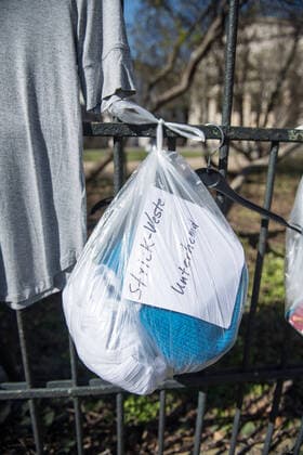 Bekleidung am Spendenzaun an der Evangelische Kirchengemeinde am Weinberg in Berlin-Mitte (Foto vom 24.03.2020). In ganz Deutschland entstehen derzeit sogenannte Spenden- oder Gabenzaeune fuer Obdachlose. Die Menschen werden dazu aufgerufen, in Plastiktueten verpackte Lebensmittel, Hygieneartikel oder Kleiderspenden an die Zaeune zu haengen, damit sich auf der Strasse lebende oder arme Menschen dort versorgen koennen. Wegen der Corona-Pandemie haben viele soziale Einrichtungen wie Tafeln, Nachtcafes und Suppenkuechen aus Infektionsschutzgruenden mittlerweile geschlossen. (Siehe epd-Meldung vom 24.03.2020) Gabenzaeune fuer Obdachlose in ganz Deutschland