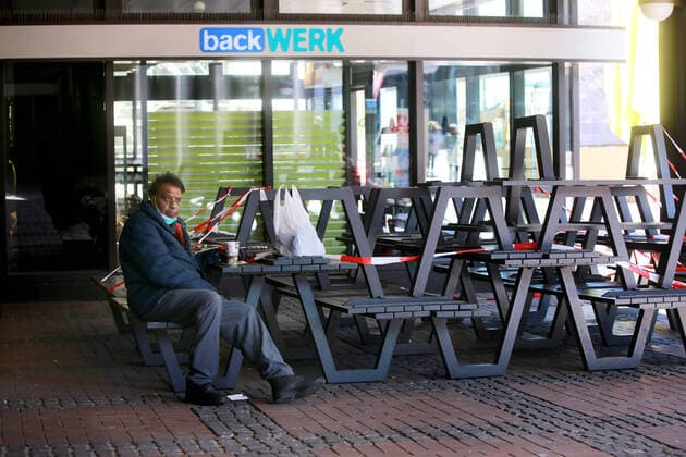 24.03. 2020 Dortmund, NRW Die Coronakrise verschärft sich. Die Bundes- und Landesregierungen erlassen umfasssenden Richtlinien. In allen Lebensbereichen erleben auch die Dortmunder Bürger starke Einschränkungen.. Auch die Außengastronomie der Bäckerein hat geswchlossen und die Sitzplätze abgesperrt. Es gibt überall nur noch coffee to go. Diesewr Passant hat sich einen Platz auf der Kante einer Sitzbank ergattert.