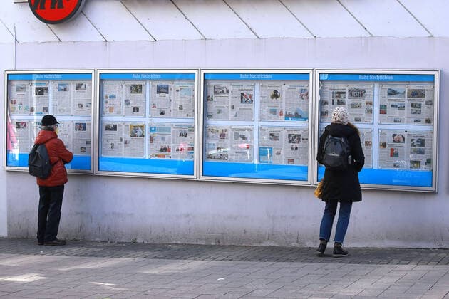 24.03. 2020 Dortmund, NRW Die Coronakrise verschärft sich. Die Bundes- und Landesregierungen erlassen umfasssenden Richtlinien. In allen Lebensbereichen erleben auch die Dortmunder Bürger starke Einschränkungen.. Interessierte Bürger lesen die im offenen Zeitungskasten ausgehängten Ruhr-Nachrichten. Auch hier wird auf dem Abstand zueinander geachtet.