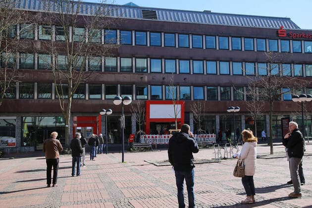 24.03. 2020 Dortmund, NRW Die Coronakrise verschärft sich. Die Bundes- und Landesregierungen erlassen umfasssenden Richtlinien. In allen Lebensbereichen erleben auch die Dortmunder Bürger starke Einschränkungen.. In Dortmund ist nur die Hauptstelle der Sparkasse für den Publikumsverkehr geöffnet. Die Kunden stehen in einer langen Schlange vor dem Eingang.
