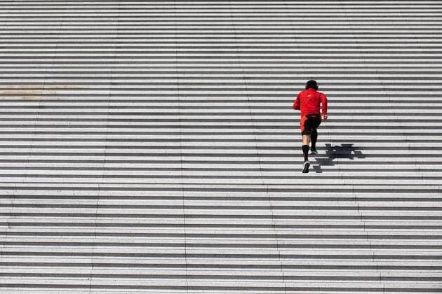 Puteaux, France, March 24, 2020 - Atmosphere in the business district of La Defense after the head of state ordered people to stay home to stop the spread of Covid-19 - A man is doing a little sport on the steps of the Grande Arche de La Defense.  Copyright: xAlexisxSciardx