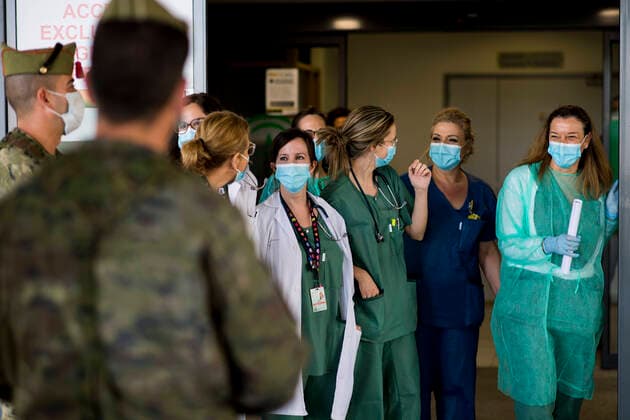 March 24, 2020, Granada, Spain: Health staff having a talk with members of the Spanish Army Legion at the gate of the San Cecilio clinical hospital, during the covid-19 pandemic..After 11 days of the state of emergency in Spain due to the coronavirus outbreak, there are more than 29,900 infected and 2,700 deaths. Granada Spain - ZUMAs197 20200324_zaa_s197_042 Copyright: xCarlosxGilx