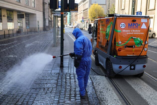 March 24, 2020, Cracow, Lesser Poland, Poland: Worker wearing a protective suit as a preventive measure while doing the disinfection during the corona pandemic..Municipal cleaning services spray disinfectants in public places, including public transport stops as a preventive measure against the coronavirus pandemic. Cracow Poland - ZUMAs197 20200324_zaa_s197_075 Copyright: xFilipxRadwanskix