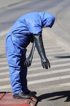 March 24, 2020, Cracow, Lesser Poland, Poland: Worker putting on his protective outfit as a preventive measure during the corona pandemic..Municipal cleaning services spray disinfectants in public places, including public transport stops as a preventive measure against the coronavirus pandemic. Cracow Poland - ZUMAs197 20200324_zaa_s197_077 Copyright: xFilipxRadwanskix