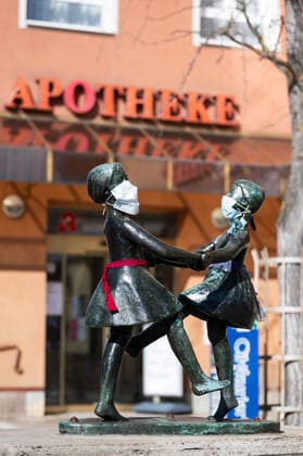 Unbekannte haben an die Statue zweier tanzender Mädchen im Zentrum von Jena Atemschutzmasken angebracht. Die Statue steht vor einer Apotheke. Foto vom 24.3.2020
