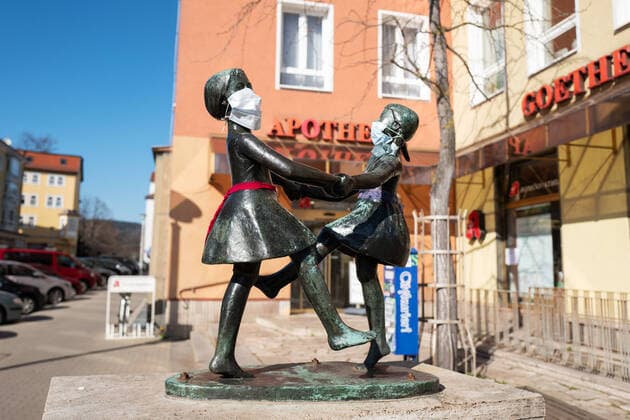 Unbekannte haben an die Statue zweier tanzender Mädchen im Zentrum von Jena Atemschutzmasken angebracht. Die Statue steht vor einer Apotheke. Foto vom 24.3.2020