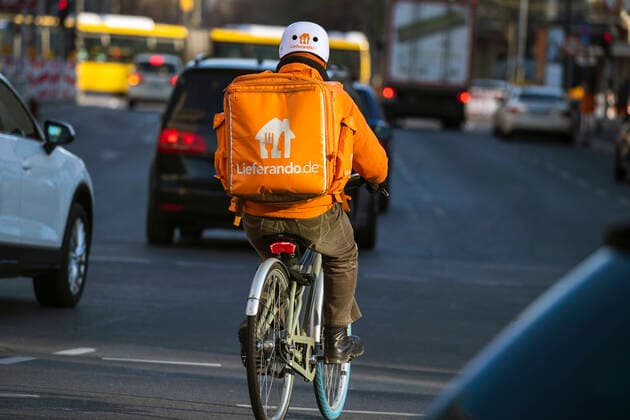 Ein Lieferant von Lieferando auf dem Fahrrad in Berlin am 24. Maerz 2020. Um die Verbreitung des Coronavirus (COVID-19) zu verlangsamen beschlossen Bund und Laender weitere Restriktionen. Nachdem Museen, Theatern, Sportveranstaltungen usw verboten wurden sind ab gestern Versammlungen mit mehr als zwei Personen in der Oeffentlichkeit grundsaetzlich verboten. Restaurants koennen zum Beispiel nur nich Abholung anbieten. Die Menschen scheinen diese Massnahmen zu folgen, da die Stadt menschenleer ist. Oeffentliches Leber weiter in Berlin wegen Coronavirus eingeschraenkt