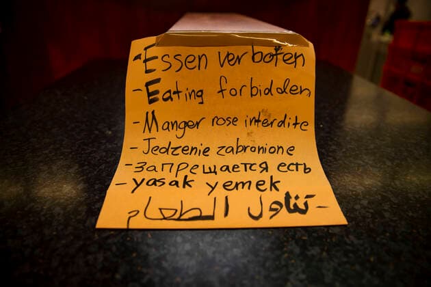 Ein Schild Essen Verboten in vielen Sprachen in einem Imbiss in Berlin am 24. Maerz 2020. Um die Verbreitung des Coronavirus (COVID-19) zu verlangsamen beschlossen Bund und Laender weitere Restriktionen. Nachdem Museen, Theatern, Sportveranstaltungen usw verboten wurden sind ab gestern Versammlungen mit mehr als zwei Personen in der Oeffentlichkeit grundsaetzlich verboten. Restaurants koennen zum Beispiel nur nich Abholung anbieten. Die Menschen scheinen diese Massnahmen zu folgen, da die Stadt menschenleer ist. Oeffentliches Leber weiter in Berlin wegen Coronavirus eingeschraenkt