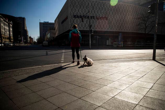 Eine junge Frau spaziert mit ihrem Hund in Berlin am 24. Maerz 2020. Um die Verbreitung des Coronavirus (COVID-19) zu verlangsamen beschlossen Bund und Laender weitere Restriktionen. Nachdem Museen, Theatern, Sportveranstaltungen usw verboten wurden sind ab gestern Versammlungen mit mehr als zwei Personen in der Oeffentlichkeit grundsaetzlich verboten. Restaurants koennen zum Beispiel nur nich Abholung anbieten. Die Menschen scheinen diese Massnahmen zu folgen, da die Stadt menschenleer ist. Oeffentliches Leber weiter in Berlin wegen Coronavirus eingeschraenkt