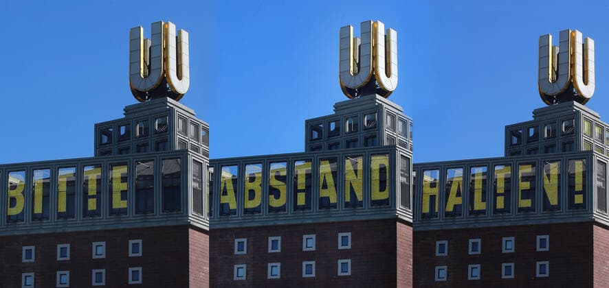 24.03. 2020 Dortmund, NRW Die Coronakrise verschärft sich. Die Bundes- und Landesregierungen erlassen umfasssenden Richtlinien. In allen Lebensbereichen erleben auch die Dortmunder Bürger starke Einschränkungen.. Politisch aktuell zeigt das Laufband an der Bilderuhr von Adolf Winkelmann auf dem Dortmunder U Bitte haltet Abstand in den BVB-Farben in scharz-gelb gestaltet. Montage