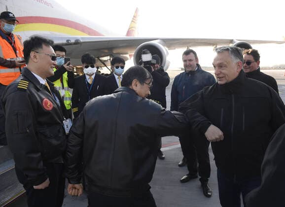 (200324) -- BUDAPEST, March 24, 2020 (Xinhua) -- Hungarian Prime Minister Viktor Orban (R, Front) greets a Chinese crew with elbow-bumps at the Budapest Liszt Ferenc International Airport in Budapest, Hungary, on March 24, 2020. A new shipment from China, carrying supplies purchased by the Hungarian government to battle the COVID-19, arrived at the airport on Tuesday. (Tamas Kovacs MTI Handout via Xinhua) HUNGARY-BUDAPEST-COVID-19-MEDICAL SUPPLIES FROM CHINA-ARRIVAL 